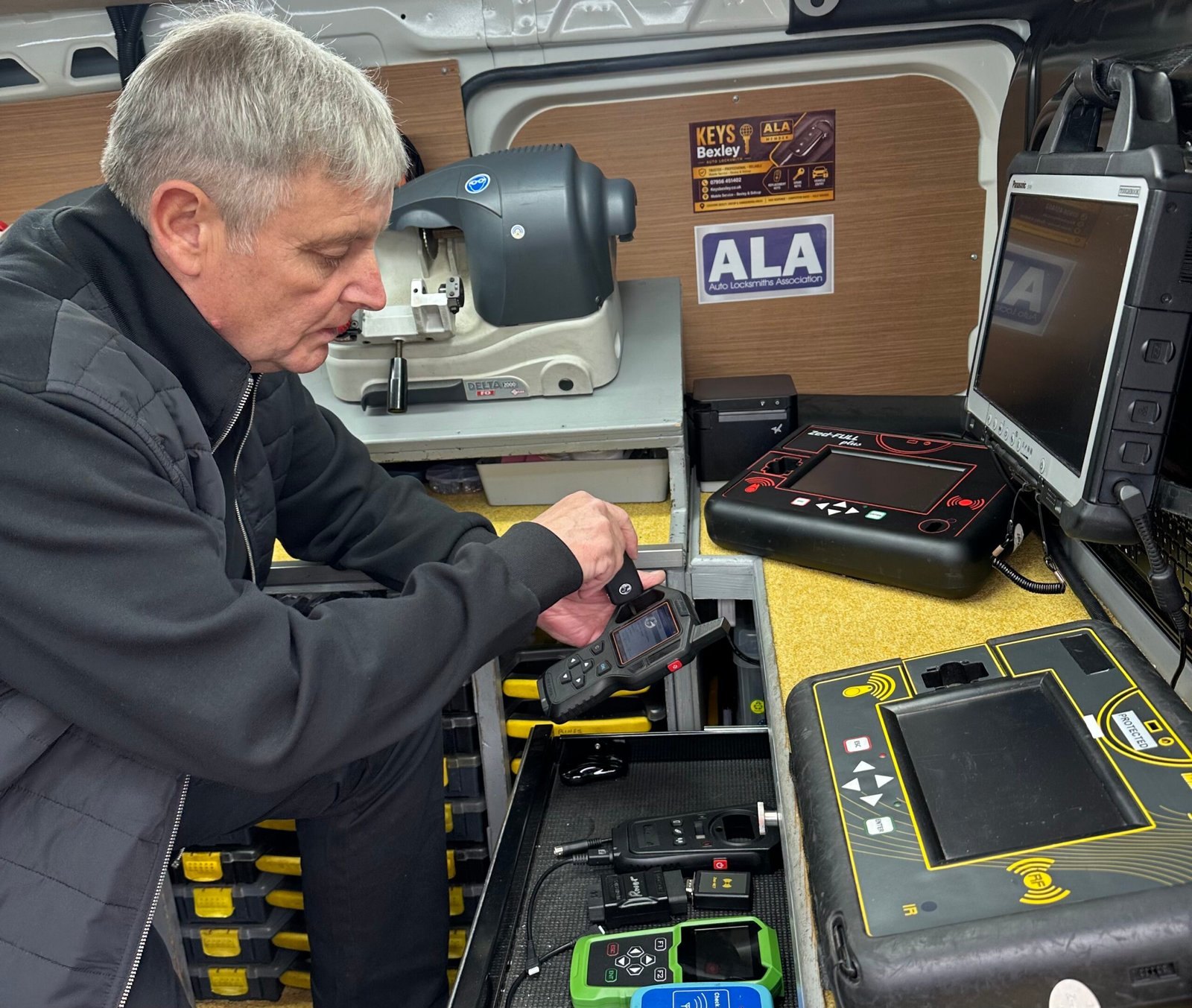 Terry using specialist car key programming equipment in the Keys Bexley mobile workshop